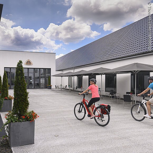 Radfahrer vor dem Museum für historische Maybach Fahrzeuge Neumarkt Deutschland, Bayern, Oberpfalz, Neumarkt, Museum für historische Maybach Fahrzeuge, Eingang, Fahrradfahrer, radfahren, ebikeengl. Germany, Bavaria, Upper Palatinate, Neumarkt, entrance museum for historical Maybach cars, cycling, cyclists, ebike, ebiking